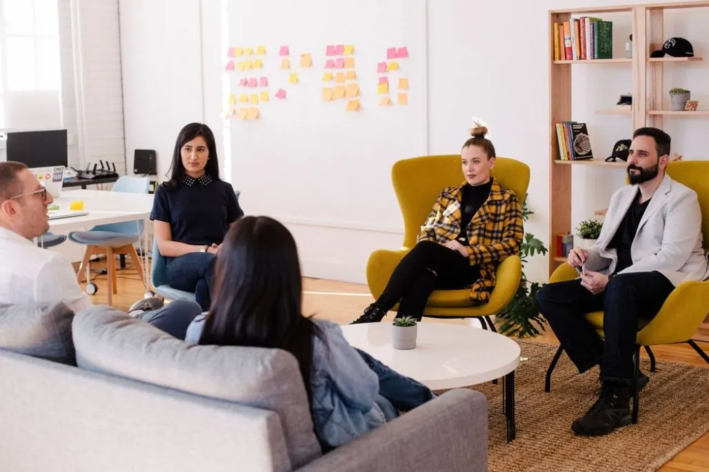 Best company intranet - group of employees sitting in a circle having a meeting