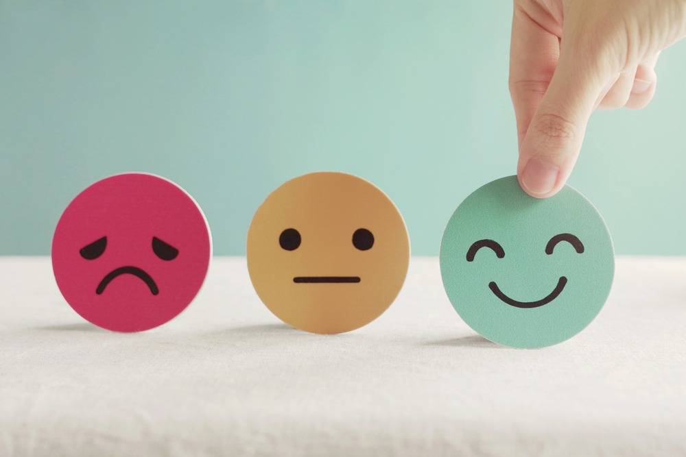 Employee experience - three paper faces ranging from smile to frown, color ranging from green for good to red for bad