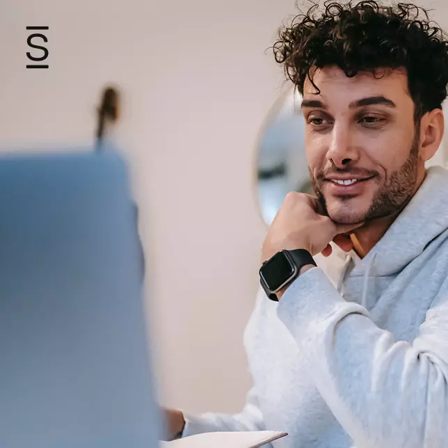 Internal communication - man wearing hoodie and smartwatch using laptop computer