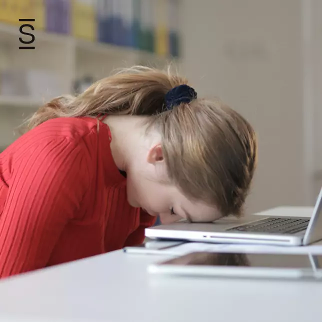 Intranet - exhausted woman keeping her head down in front of laptop screen