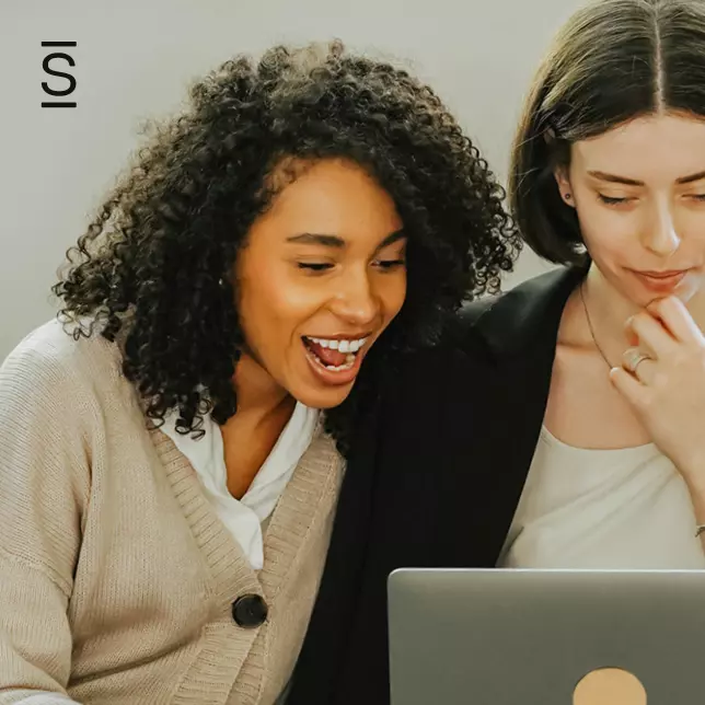 Intranet - two female employees reacting to something on laptop screen