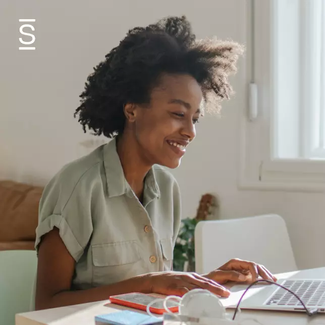 Benefits of an intranet - woman smiling and looking at computer screen