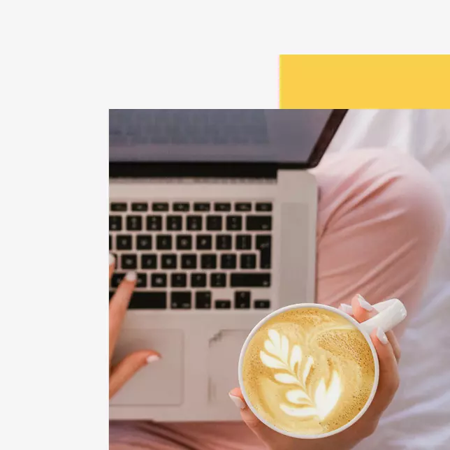 Employee experience - closeup of a coffee cup with a milk froth leaf and a laptop computer