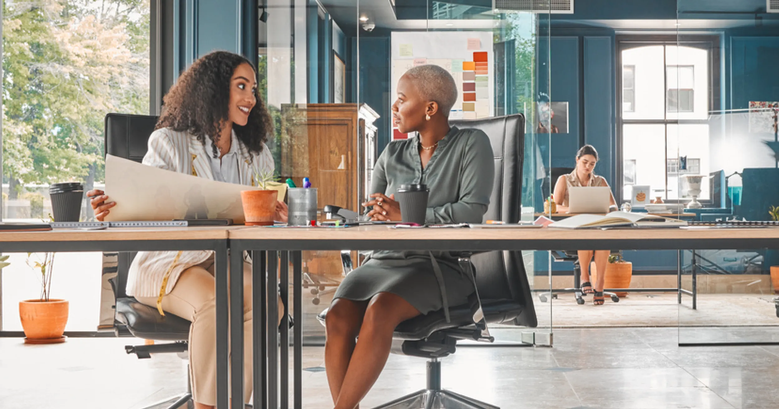 Employee development plan - two female employees working together in an open office space